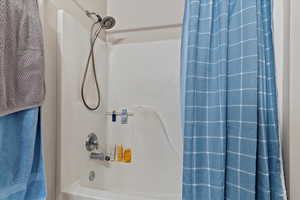 Bathroom with shower / bathtub combination with curtain