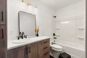 Full bathroom featuring vanity, shower / tub combination, and toilet