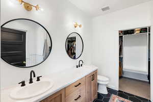 Bathroom with vanity, toilet, and tile patterned floors