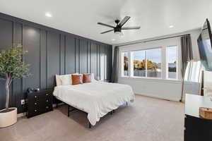 Carpeted bedroom featuring ceiling fan