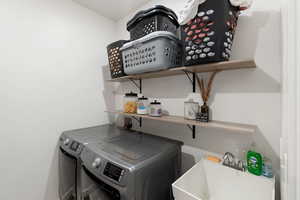 Clothes washing area featuring sink and washer and clothes dryer