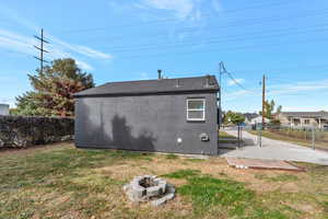 Rear view of house with a patio area, outdoor fire pit, and a lawn