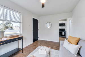 Living room featuring front entrance, ceiling fan, hardwood / wood-style flooring, and a textured ceiling