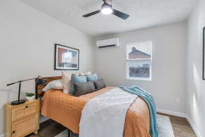 Bedroom featuring ceiling fan,  light hardwood / wood-style flooring, and a mini split heating and cooling unit