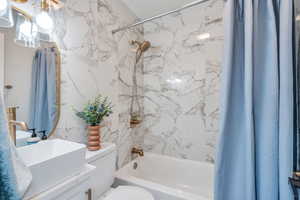 luxury tile bathroom with new vanity, toilet, and shower / bath combo