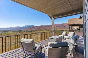 Wooden terrace featuring a mountain view and outdoor lounge area