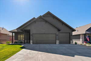 Craftsman house featuring a front yard and a garage