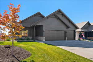 Craftsman inspired home featuring a front lawn and a garage