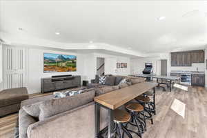 Living room with light hardwood / wood-style floors, wine cooler, and sink