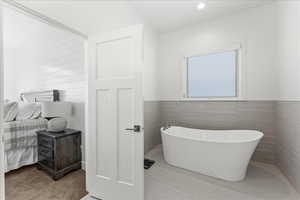 Bathroom with a tub to relax in and tile walls