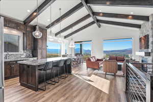 Kitchen with light hardwood / wood-style floors, a mountain view, light stone counters, and hanging light fixtures