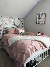 Bedroom featuring lofted ceiling and carpet flooring