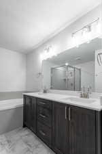 Bathroom featuring vanity, shower with separate bathtub, and a textured ceiling