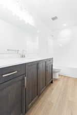 Full bathroom featuring vanity, toilet, hardwood / wood-style flooring, and shower / tub combination