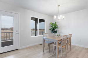 Dining area with light hardwood / wood-style floors and an inviting chandelier