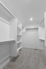 Walk in closet featuring light colored carpet