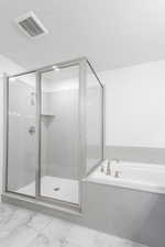 Bathroom featuring a textured ceiling and plus walk in shower