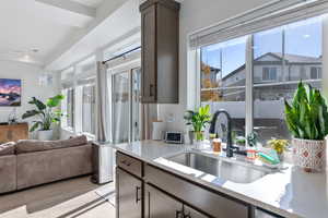 Kitchen featuring light hardwood / wood-style flooring, dark brown cabinetry, and sink