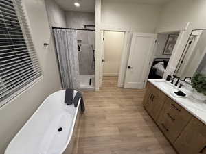 Bathroom with shower with separate bathtub, vanity, and hardwood / wood-style flooring