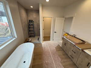 Bathroom featuring hardwood / wood-style floors, shower with separate bathtub, and plenty of natural light