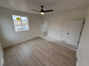 Unfurnished bedroom featuring a closet, ceiling fan, and light hardwood / wood-style flooring