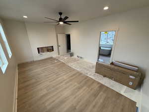 Unfurnished living room with light wood-type flooring and ceiling fan