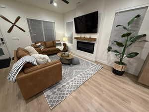 Living room with ceiling fan and light hardwood / wood-style floors