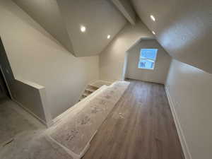 Additional living space featuring vaulted ceiling and hardwood / wood-style flooring