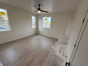 Unfurnished room with a textured ceiling, light hardwood / wood-style floors, and ceiling fan