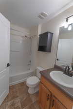 Full bathroom Second Bedroom featuring vanity, shower / bath combination, a textured ceiling, and toilet