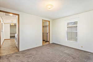 Spare room featuring washer and dryer and light colored carpet