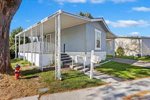 View of front of property featuring covered porch and a front lawn