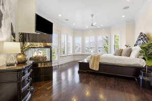 Bedroom featuring ornamental molding, dark wood-type flooring, and ceiling fan