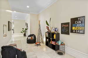 Hallway featuring crown molding and light tile patterned floors