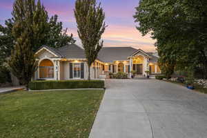 Ranch style home featuring concrete driveway and frontyard.