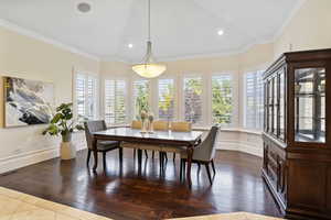 Dining space featuring ornamental molding and dark hardwood / wood-style floors