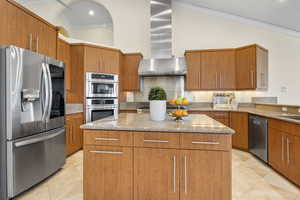 Kitchen featuring a center island, appliances with stainless steel finishes, and vaulted ceiling