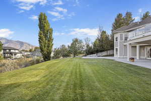 View of yard featuring a balcony, a mountain view, and a patio