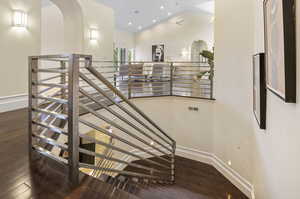 Stairs with hardwood / wood-style floors and vaulted ceiling