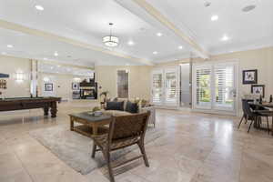 Living room with crown molding, beamed ceiling, and pool table