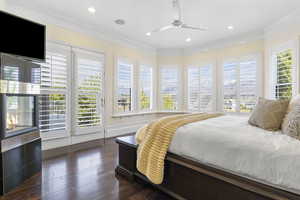 Bedroom featuring access to exterior, ceiling fan, multiple windows, and dark hardwood / wood-style flooring