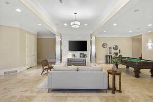 Living room with ornamental molding and billiards