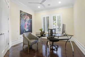 Office with ornamental molding, dark wood-type flooring, and ceiling fan