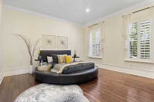 Bedroom with wood-type flooring, multiple windows, and ornamental molding