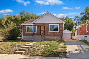 Bungalow with an outdoor structure and a garage