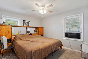 Bedroom featuring ceiling fan, carpet flooring, and cooling unit