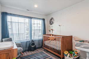 Bedroom with sink, hardwood / wood-style floors, and a nursery area