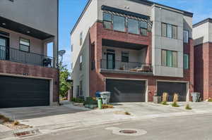 View of front of property featuring a garage and a balcony