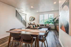 Dining area with a textured ceiling and dark hardwood / wood-style flooring