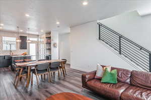 Dining space with a textured ceiling and dark hardwood / wood-style flooring